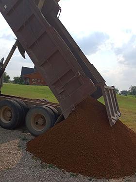 dark red dirt dumped by truck