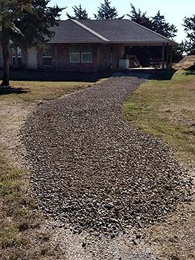 Trail of rock spread out in front of home on old dirt driveway